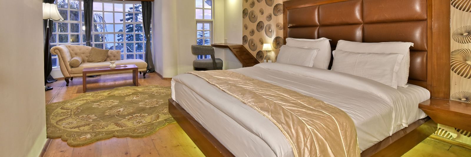 Suite with a king size bed and a living area at DLS Hillcrest Resort, Shimla.